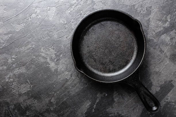 istock Empty cast iron frying pan on dark grey culinary background, view from above 695265002