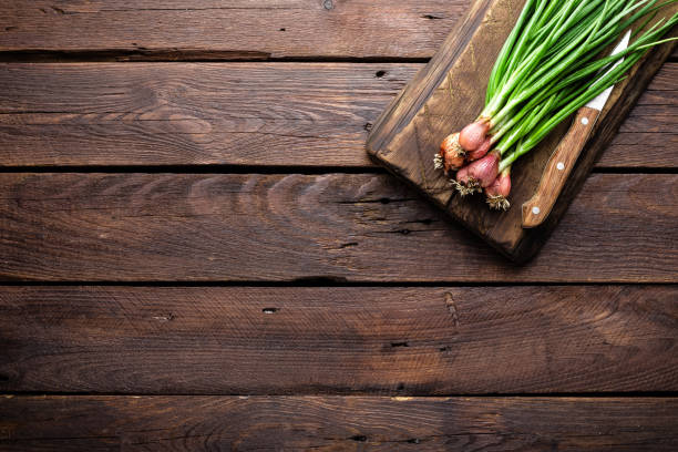 istock Green onion or scallion on wooden board, fresh spring chives 695265010