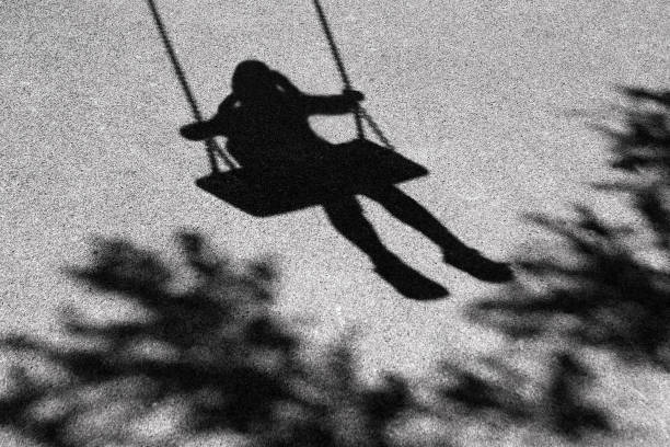 Girl on a swing shadow stock photo