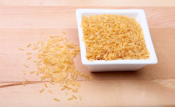 istock Rice in a bowl on wooden background. ready for cooking. 695270082