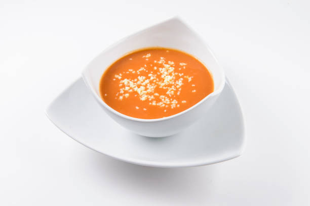 tomato soup with cheese in white porcelain bowl on white