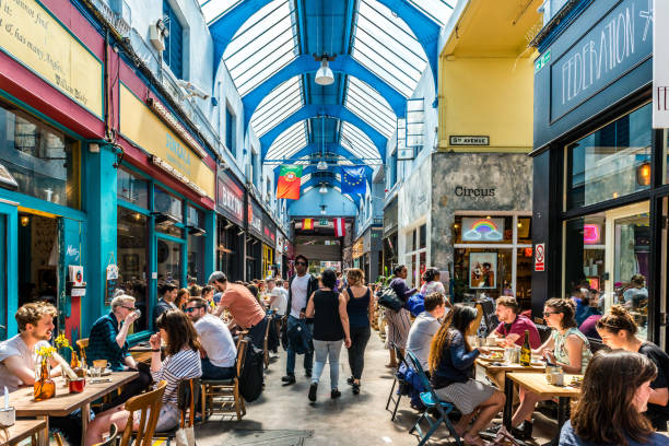 People in cafes and bars London: Brixton Village and Brixton Station Road Market. Colorful and multicultural community market run by local traders in South London. Cafes and bars brixton stock pictures, royalty-free photos & images