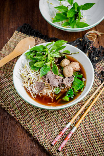 istock asian noodle soup with beef meatball with fresh vegetable on wood table 695294608