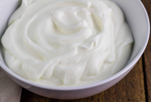 istock Natural yoghurt close up in bowl on rustic wooden table 695305500