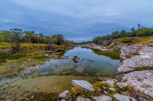 Crystal Clear Stream Flowing Through the Wild Western Texas Hill Country with Autumn Colors on an Overcast Sleepy Day.