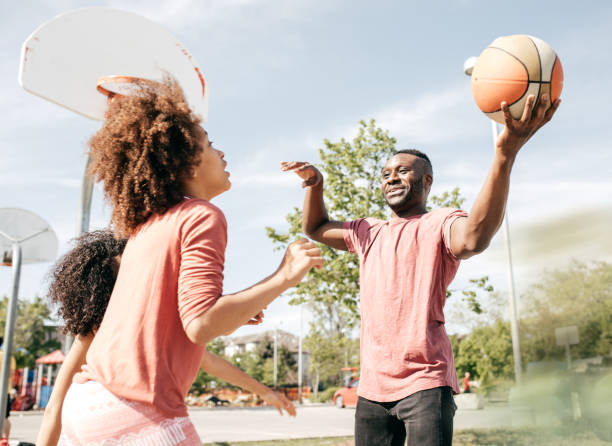 istock Father playing basketball with daughters 695319076