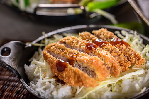 Deep Fried Pork Cutlets on chopped green cabbage and white rice
