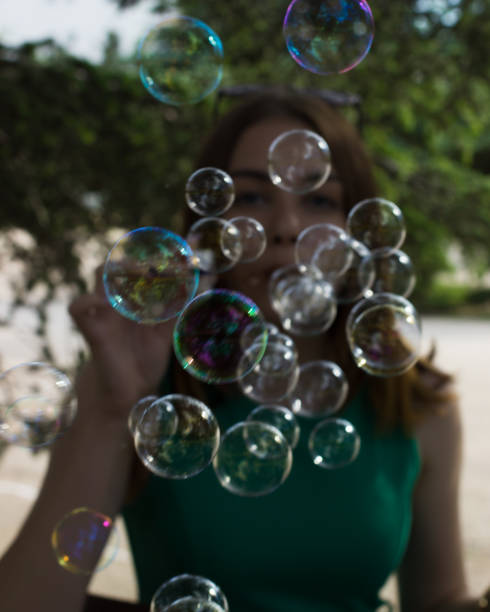 istock Young pretty girl blows bubbles, outdoor 695325786