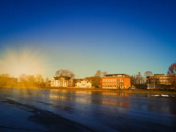 Photo of Cityscape near the river in winter season with gold light and navy blue sky background, Karlstad, Sweden