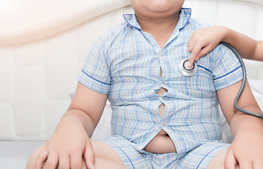 Little hand doctor check heart by stethoscope to obese asian boy, healthcare concept
