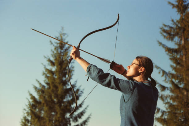 Brave little archer aiming at the evil dragon. The girl is about to release the arrow. The girl is aged 6