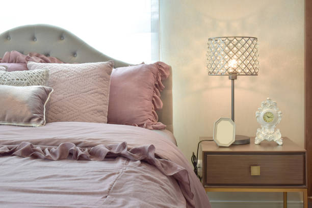 istock Cozy and classic bedroom interior with pillows and crystal  reading lamp on bedside table 695334568