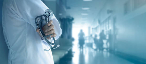 medico con stetoscopio in mano su sfondo ospedaliero - oggetto generale foto e immagini stock