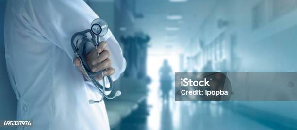Doctor With Stethoscope In Hand On Hospital Background Stock Photo - Download Image Now
