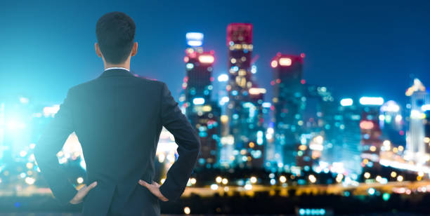 istock Businessman looking at city night 695341240