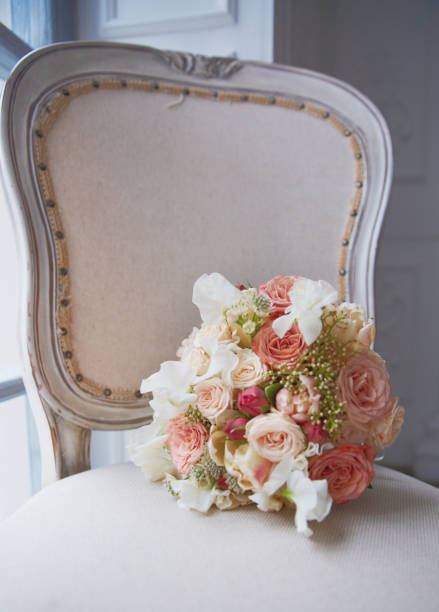 istock Brides bouquet lays on antique chair 695343750