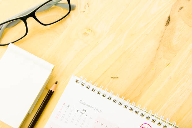 istock Glasses, pencil with notebook and calendar on work space wooden. top view, flat lay concept. 695343996