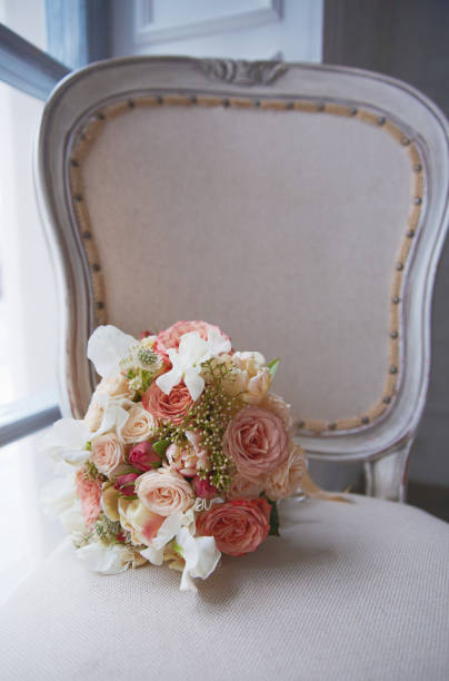 istock Brides bouquet lays on antique chair 695344042