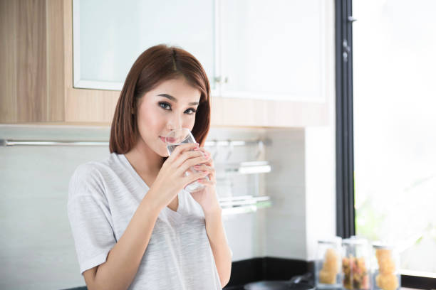 istock relaxed young smiling woman drinking clean water 695353932
