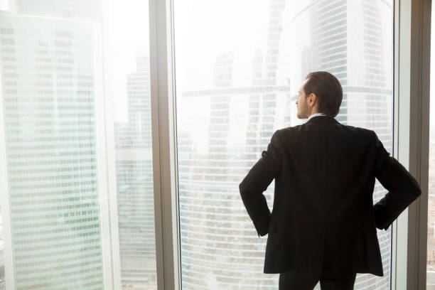 istock Businessman thinking about future near window 695358910