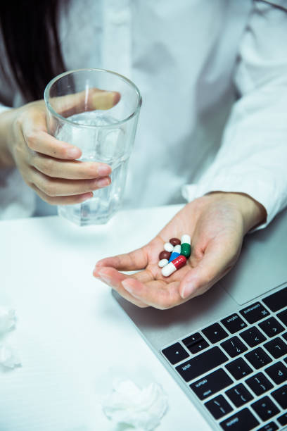 istock Woman taking pills in office 695372814