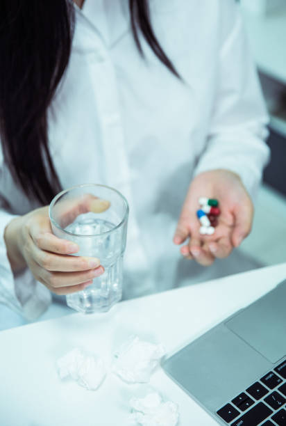 istock Woman taking pills in office 695372866
