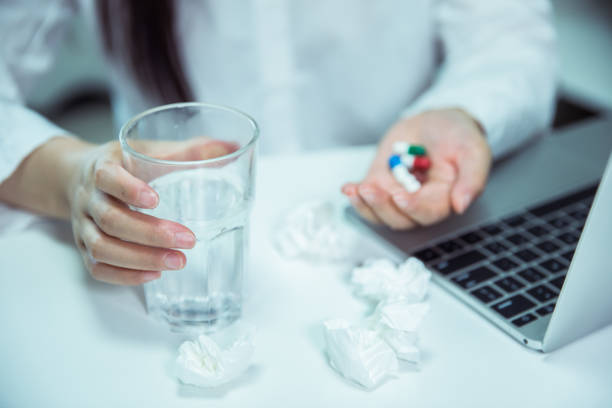 istock Woman taking pills in office 695372912