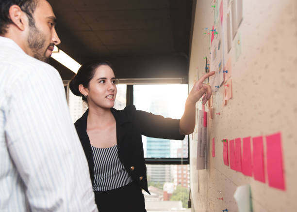 istock Businesswoman  doing brainstorming meeting at the office. Documents on wall. 695373146