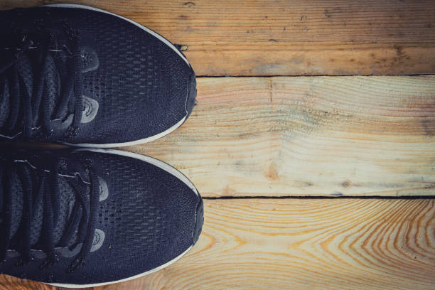 istock Running shoes on wood background texture with space 695381262