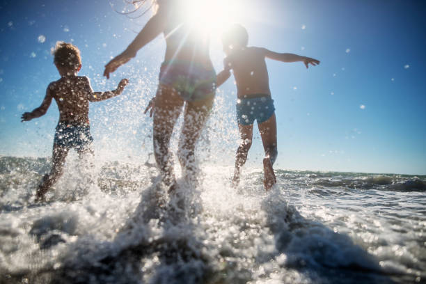 niños felices corriendo en el mar - spraying beaches summer sunlight fotografías e imágenes de stock