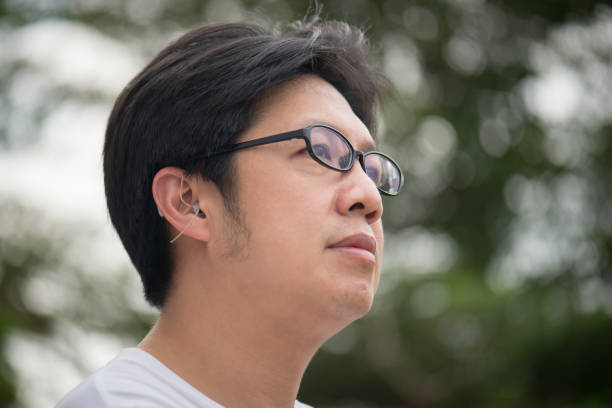 istock man with hearing aid behind the ear 695387452