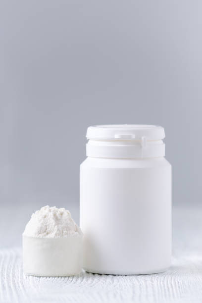istock a spoon with white powder and a bottle on gray, selective focus 695393196