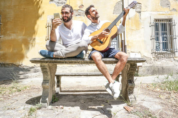 istock Two adult men playing guitar and using the phone 695410438