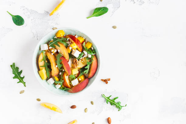 桃のサラダ。ほうれん草の葉、桃、マンゴー、ナッツのスライス、ルッコラ - nut directly above multi colored food ストックフォトと画像
