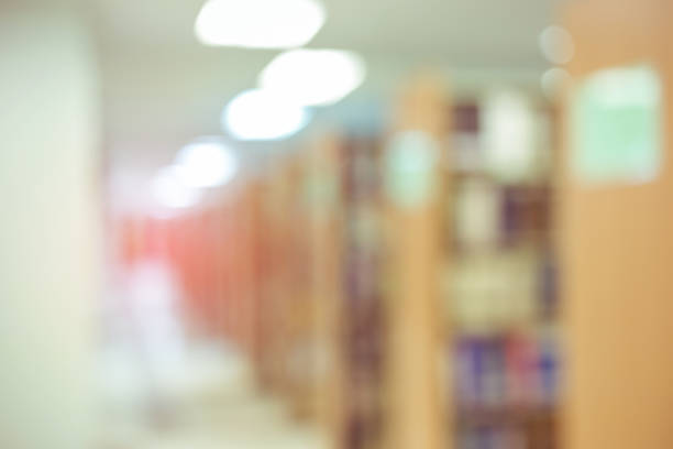 istock books on bookshelf in library, abstract blur defocused background 695415510