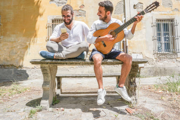 istock Two adult men playing guitar and using the phone 695415654