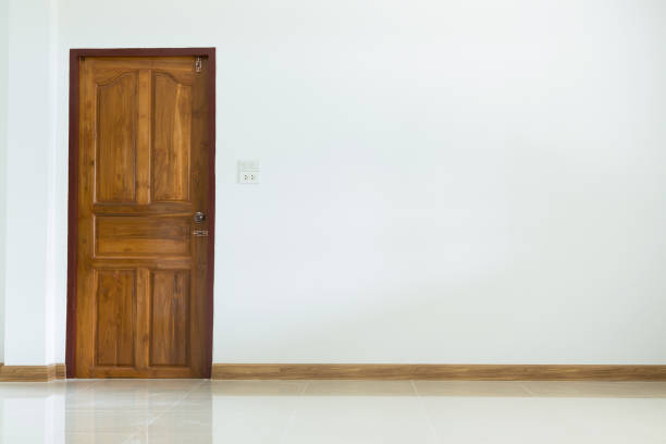 istock empty room interior with wooden door and white mortar wall 695416534
