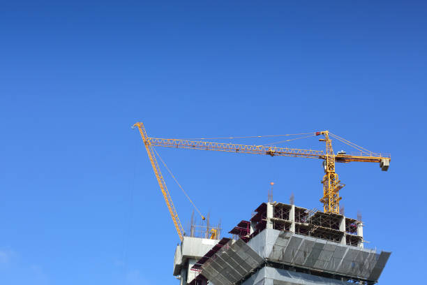 istock machinery crane in construction site building industry with clear blue sky background 695420348
