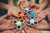 Hands holding fidget spinners