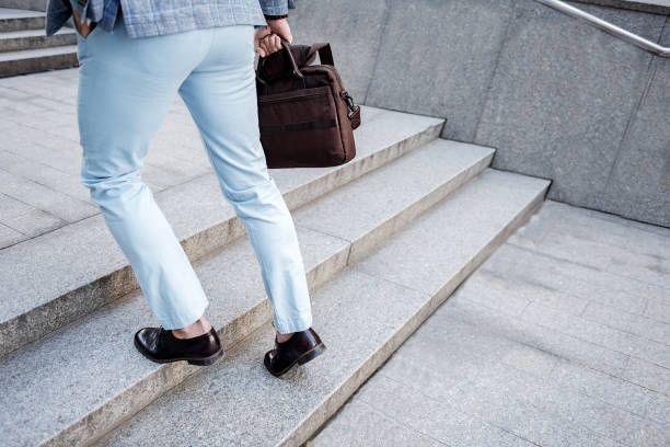 istock Active elegant male person overcoming stairs 695425212
