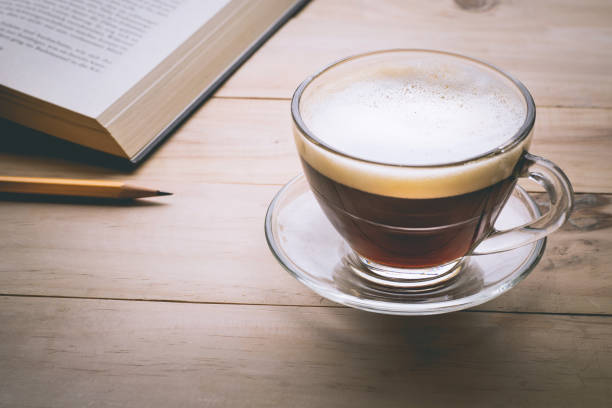 istock Coffee cup with book on wood table in morning 695429610