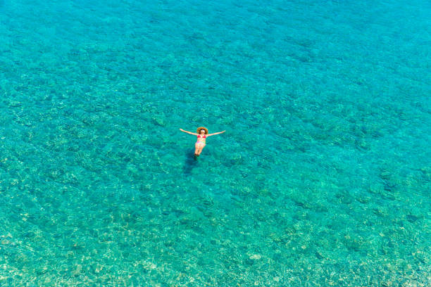 istock Girl floating in the sea 695433704