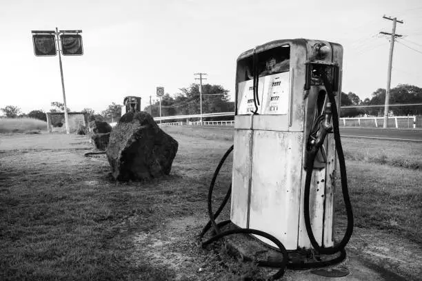Rusted old pump at the front of an abandoned fuel station. Black and White.