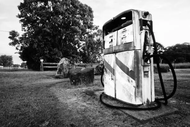 Rusted old pump at the front of an abandoned fuel station. Black and White.