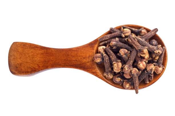 istock Spice cloves on wooden spoon isolated on white background. 695437826