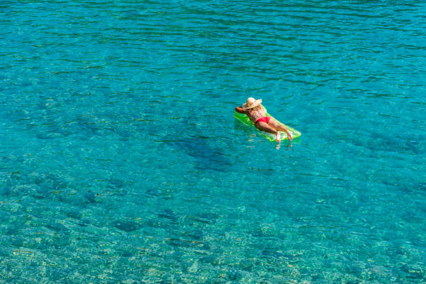 istock Girl floating in the sea 695438384