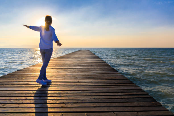istock Freedom – Woman on Lakeside Jetty 695438956