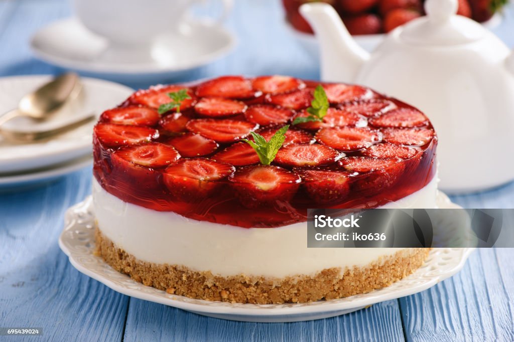 Homemade strawberry cheesecake on blue wooden background. Strawberry Stock Photo