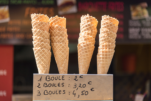 Ice cream cones and a label with the ice cream prices written in French, street ice cream shop in summer, France