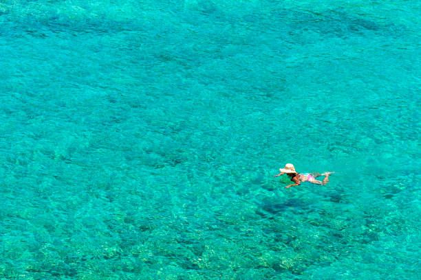 istock Girl floating in the sea 695447980